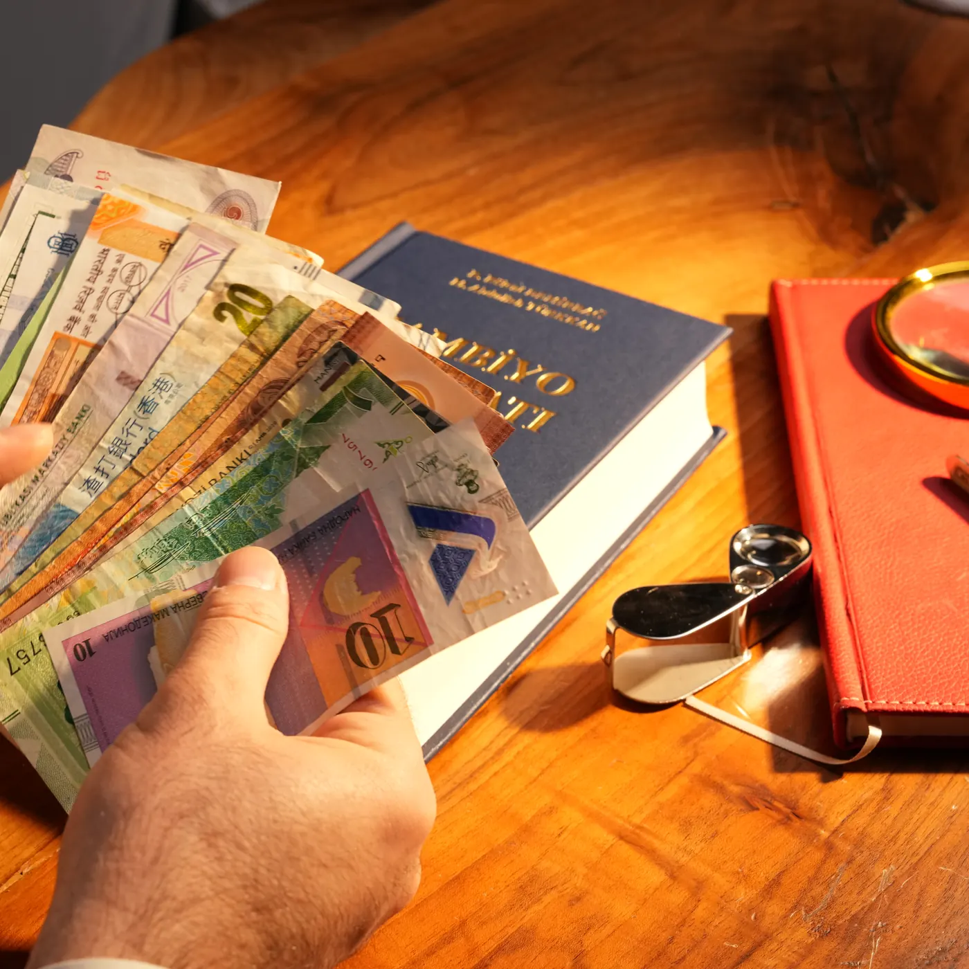 Yabancı banknot destesi sayan eller.